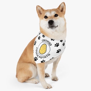 Puede incluir: Un perro Shiba Inu con un pa&ntilde;uelo blanco con huellas de patas negras y las palabras "CERTIFIED COUCH POTATO" alrededor de una ilustraci&oacute;n de patata amarilla. El perro est&aacute; sentado y mirando a la c&aacute;mara.