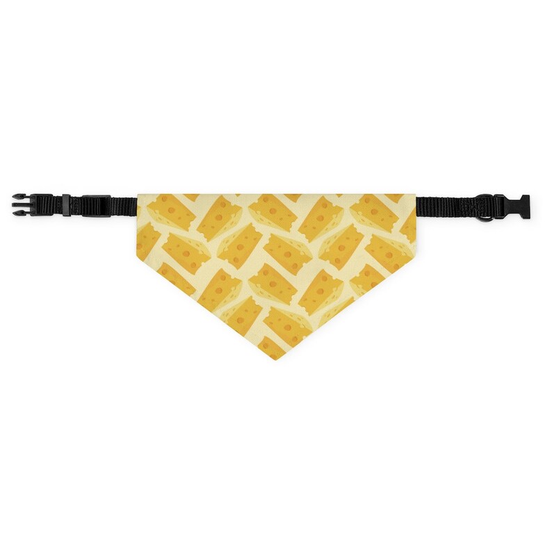 May include: A yellow and white dog bandana with a pattern of cheese slices. The bandana has black adjustable straps.