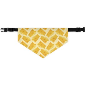 May include: A yellow dog bandana with a pattern of cheese slices. The bandana has black adjustable straps.