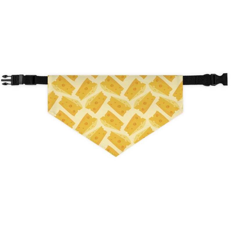 May include: A yellow dog bandana with a pattern of cheese slices. The bandana has black adjustable straps.
