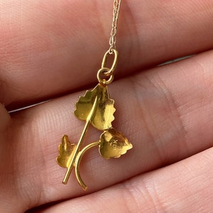 May include: A gold pendant necklace featuring a delicate design of three leaves. The pendant is marked "10K" on the reverse.