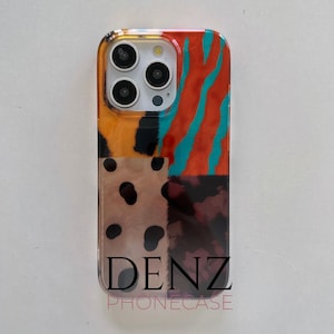 May include: A patterned phone case with a vibrant, abstract design. The case displays a patchwork of patterns, including orange and teal stripes, leopard spots, and a tortoiseshell pattern. The brand name "DENZ PHONECASE" is printed at the bottom.