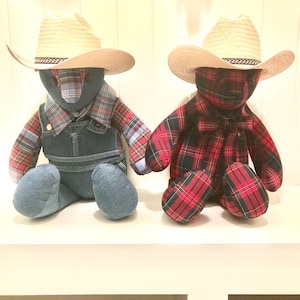 May include: Two teddy bears wearing cowboy hats. One bear is wearing a blue and red plaid shirt with denim overalls. The other bear is wearing a red and black plaid shirt.
