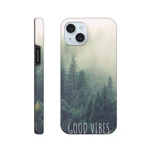 May include: A white phone case with a forest scene in shades of green and grey. The case has a black edge and the words "GOOD VIBES" in white script. The phone's camera is visible at the top. The image evokes a sense of calm.