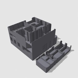 Op de afbeelding: Een grijs, 3D-geprint model van een gebouw met meerdere verdiepingen, met binnenmuren en raamuitsparingen. Er zijn ook verschillende losse modulaire onderdelen, wat wijst op een bouwpakket of model.
