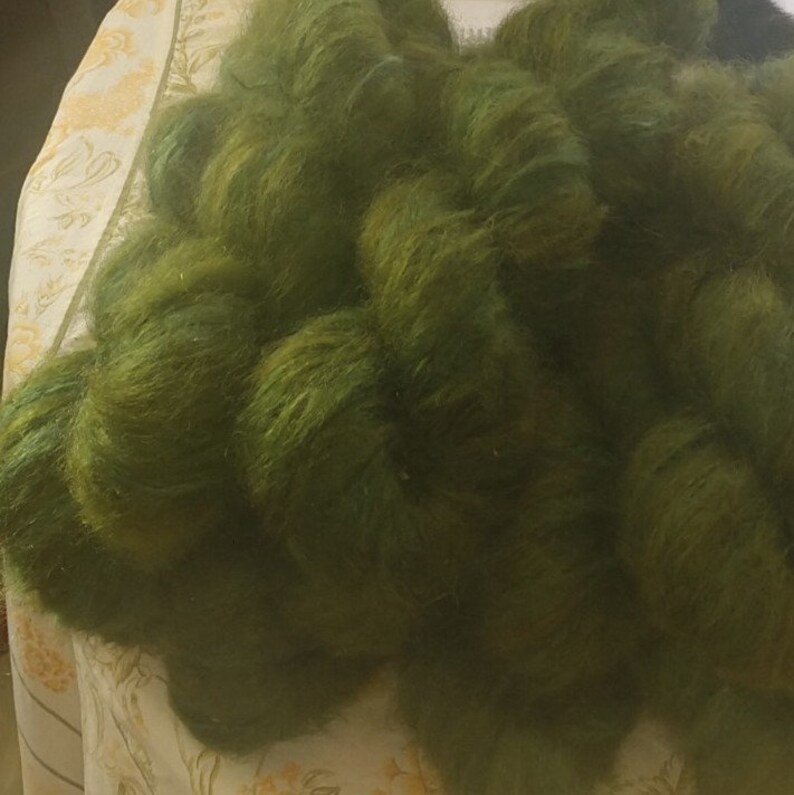 Pu&ograve; includere: Un mucchio di filato morbido e verde. Il filato &egrave; soffice e ha un aspetto leggermente strutturato.