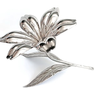 Può includere: Una tazza di ceramica bianca con manico nero e la scritta "But First, Coffee" in grassetto nero. La tazza è posta su uno sfondo sfocato, che suggerisce un'atmosfera accogliente.