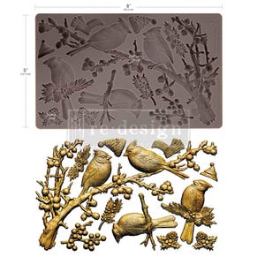 May include: A brown silicone mould featuring embossed designs of cardinals on branches with berries, pinecones, and small hats. The mould measures 20.3 cm by 12.7 cm, with individual elements measuring 21.5 cm by 10 cm and 2 cm by 3 cm.