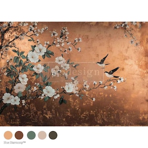 May include: A decorative panel featuring a floral design with white blossoms and green leaves on a copper-coloured background. Two birds are perched on a branch. The word "design" is visible in the centre of the image.