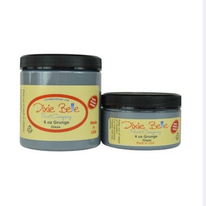 May include: Two jars of Dixie Belle Paint Company Grunge Glaze. The larger jar is 8 ounces and the smaller jar is 4 ounces. Both jars are grey and have a black lid. The jars are labelled with the Dixie Belle logo and the words "Grunge Glaze".