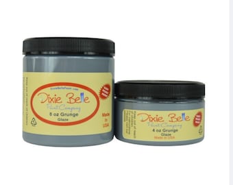 May include: Two jars of Dixie Belle Paint Company Grunge Glaze. The larger jar is 8 ounces and the smaller jar is 4 ounces. Both jars are gray and have a black lid. The jars are labeled with the Dixie Belle logo and the words "Grunge Glaze".