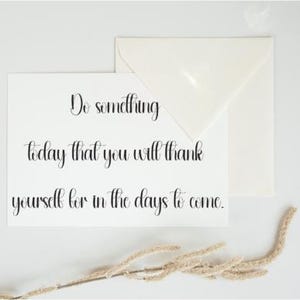 May include: A white card with the handwritten text "Do something today that you will thank yourself for in the days to come." An envelope and dried plant sprig are also present.