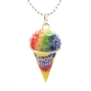 May include: A rainbow snow cone necklace with a silver chain. The snow cone is in a yellow paper cone with the words "Snow Cone" printed on it.