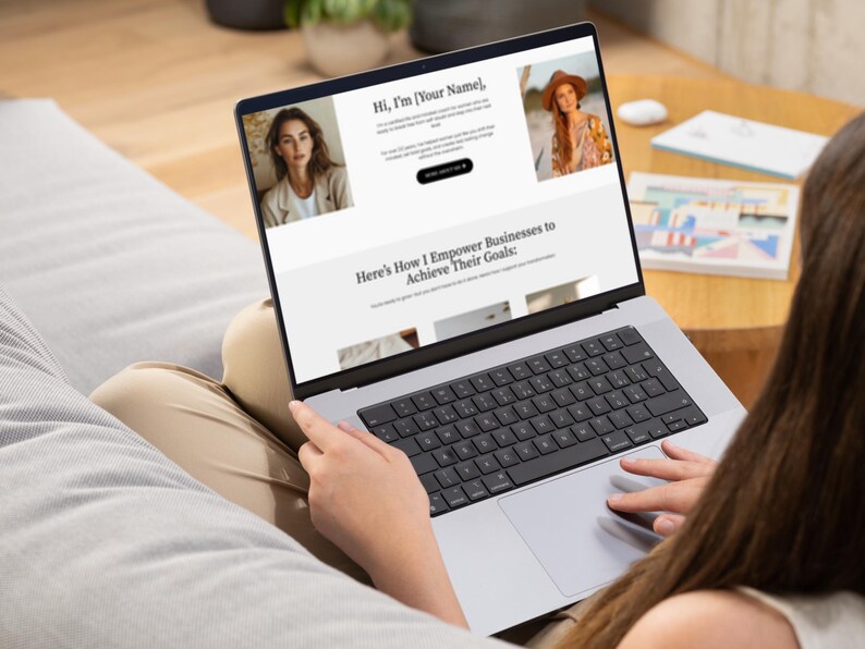K&ouml;nnte beinhalten: Eine Person benutzt einen silbernen Laptop, auf dem eine Website mit dem Text "Hi, I'm [Your Name]" und "Here's How I Empower Businesses to Achieve Their Goals:" angezeigt wird. Der Laptop befindet sich auf dem Scho&szlig; einer Person, die Tastatur ist sichtbar.