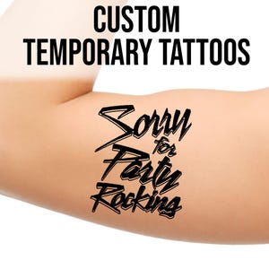 May include: A temporary tattoo on an arm with the words "CUSTOM TEMPORARY TATTOOS" at the top. Below, in a stylized font, the tattoo reads "Sorry for Party Rocking."
