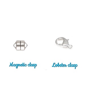 May include: Two silver-colored jewelry clasps are displayed against a white background. One is a magnetic clasp, and the other is a lobster clasp. The words "Magnetic clasp" and "Lobster clasp" are written in a light blue script below each clasp.