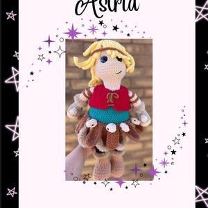 May include: A handmade crochet doll named Astrid, with blonde hair, blue eyes, and a red vest over a teal top. The doll has a brown skirt and is held in a hand. The image includes the text "Astrid" and "Copyright © 2025".
