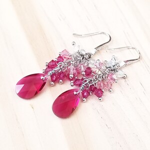 Peut inclure: Boucles d'oreilles pendantes argent&eacute;es avec un design en forme de goutte de cristal rose et clair.