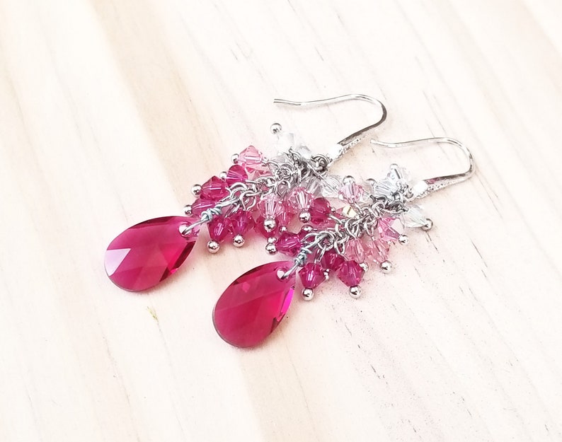 Peut inclure: Boucles d'oreilles pendantes argent&eacute;es avec un design en forme de goutte de cristal rose et clair.