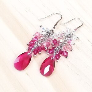 Peut inclure: Une paire de boucles d'oreilles pendantes avec des perles de cristal roses et claires et des cristaux roses en forme de goutte.