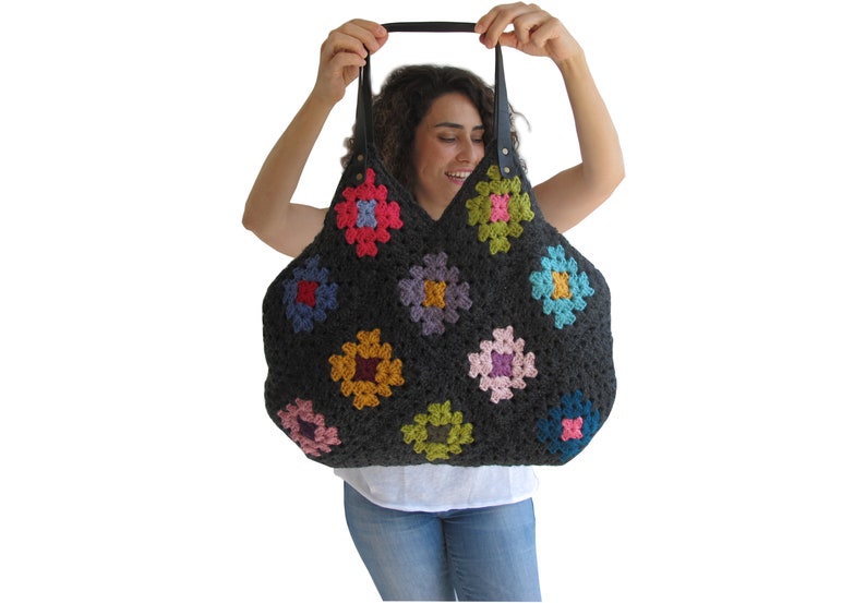 May include: A large, gray crochet tote bag with colorful granny square patches. The bag has leather handles.