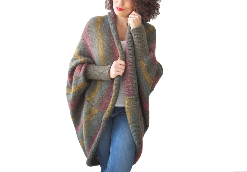 May include: A long, open-front cardigan with a striped pattern in shades of green, brown, yellow, and red. The cardigan has a relaxed fit and long sleeves.