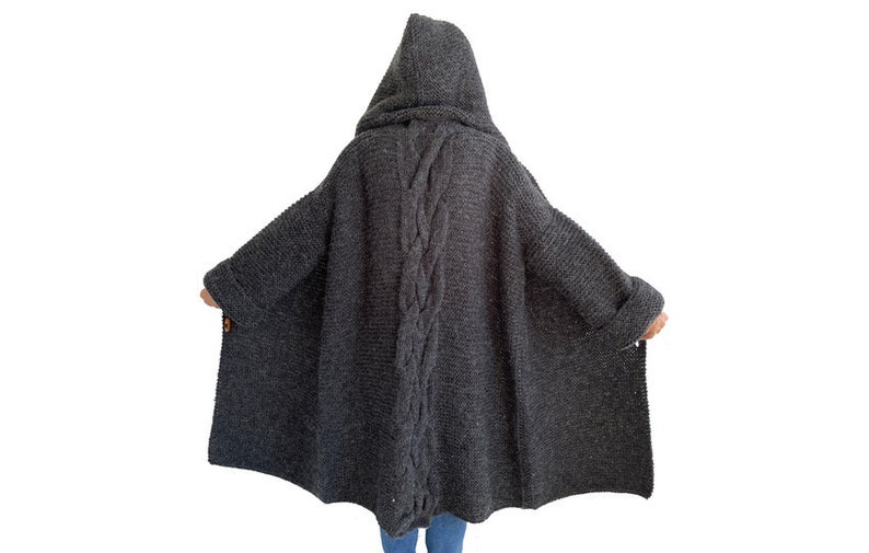 May include: A long, dark gray knitted cardigan with a hood and a braided detail down the back.