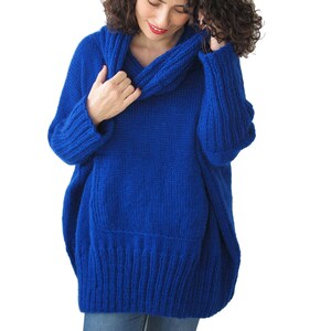 May include: A royal blue oversized sweater with a cowl neck and a ribbed hem.