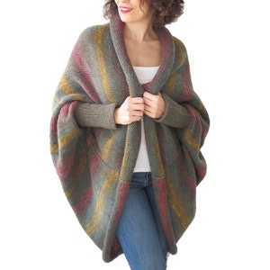 May include: A multi-coloured striped knit cardigan with long sleeves and a draped open front. The cardigan is made of a soft, textured yarn and has a relaxed fit.