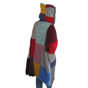 May include: A colorful patchwork knitted cardigan with a hood. The cardigan is made of different colored yarn, including red, blue, green, yellow, and purple. The cardigan has a loose fit and is perfect for layering.