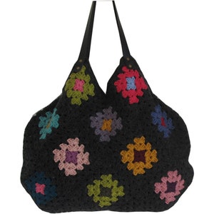 May include: A black crocheted tote bag with colorful square designs. The bag has leather straps and a wide opening.
