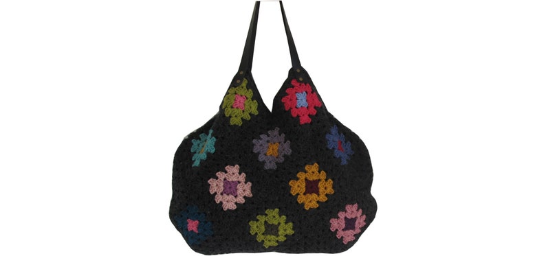 May include: A black crocheted tote bag with colorful square designs. The bag has leather straps and a wide opening.