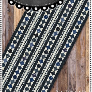 May include: A navy blue and cream table runner with a geometric pattern of diamonds and triangles. The text "Primitive Gatherings" is at the top, and "Indiana Indigo Table Runner" is at the bottom. Finished size is 16" x 35 1/2".