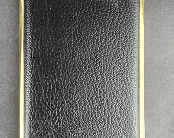 Estuche para cigarrillos de estilo vintage: acabado en cuero negro texturizado y marco de metal color dorado.