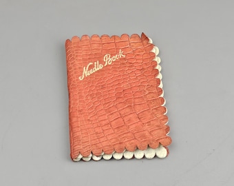 Vintage synålsbok i ett rött fodral med konstläder, samlarobjekt.