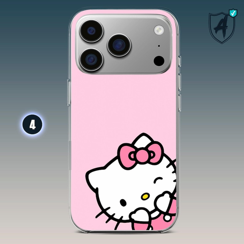 May include: Pink iPhone case featuring a Hello Kitty design. The case has a clear border and a pink background. The Hello Kitty graphic includes a pink bow and is winking. The phone case has a camera bump with three lenses.