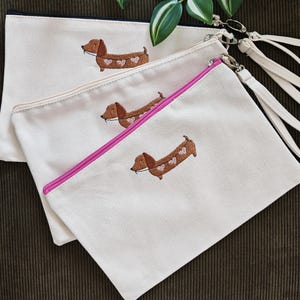 Schminktasche Hund hält Herzgirlande im Maul und Schwanz