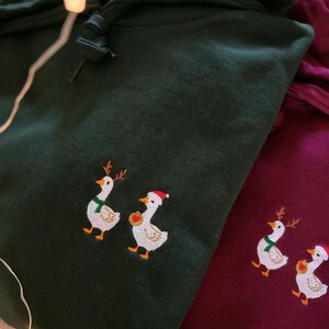 Nahaufnahme der kleinen bestickten Weihnachts Ente auf einem Hoodie, hochwertiges gesticktes Tiermotiv.