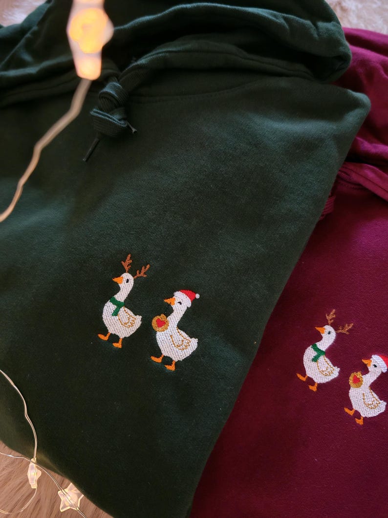 Nahaufnahme der kleinen bestickten Weihnachts Ente auf einem Hoodie, hochwertiges gesticktes Tiermotiv.