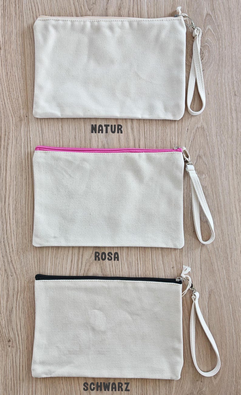 May include: Three canvas zipper pouches with a zipper pull and a strap. The pouches are all the same size and shape. The top pouch has the word "NATUR" printed below it. The middle pouch has the word "ROSA" printed below it. The bottom pouch has the word "SCHWARZ" printed below it.