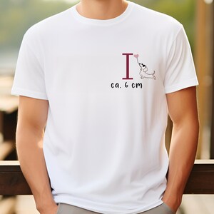 May include: White t-shirt with a graphic of a dachshund holding a heart-shaped balloon above the letter "I". The text "ca. 6 cm" is printed below the graphic.
