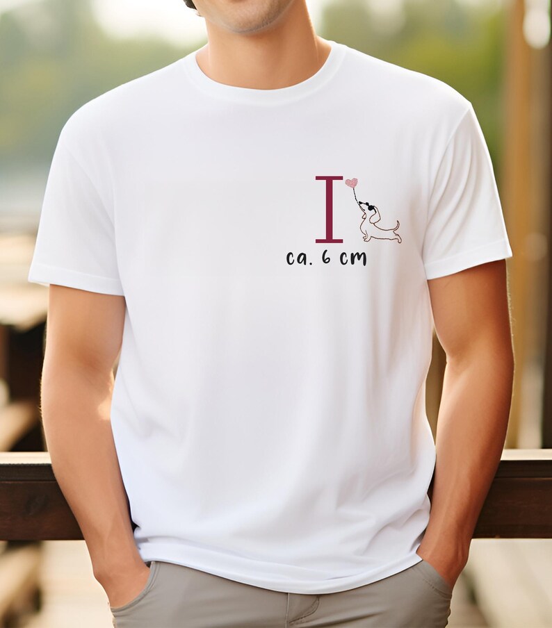 May include: White t-shirt with a graphic of a dachshund holding a heart-shaped balloon above the letter "I". The text "ca. 6 cm" is printed below the graphic.