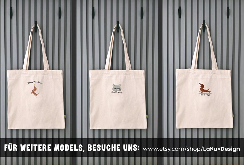 Puede incluir: Tres bolsas de tela de color beige claro con dos asas cada una. La bolsa de la izquierda muestra un perro salchicha y el texto Merry Woofmas. La bolsa central muestra una cara de gato y el texto Fluff You. La derecha muestra un perro salchicha y el texto 100% YOU.