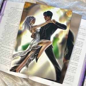 May include: An illustration of a couple dancing, with the woman in a silver dress and the man in a black suit. The artwork is on a page of a book, with text visible in the background.