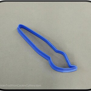 May include: Blue plastic cookie cutter shaped like a paintbrush.
