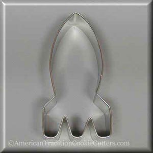 May include: A silver metal cookie cutter shaped like a rocket ship. The cutter is designed to cut out cookies in the shape of a rocket.