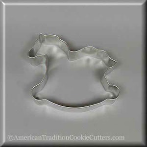 May include: A silver metal cookie cutter shaped like a rocking horse.