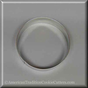May include: A silver metal cookie cutter shaped like a circle. The cutter is on a gray background.