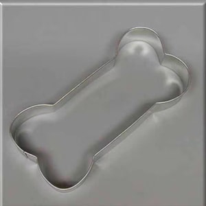 May include: A silver metal cookie cutter shaped like a dog bone.