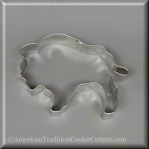 May include: A silver metal cookie cutter shaped like a bison. The cutter is designed to cut out cookies in the shape of a bison.